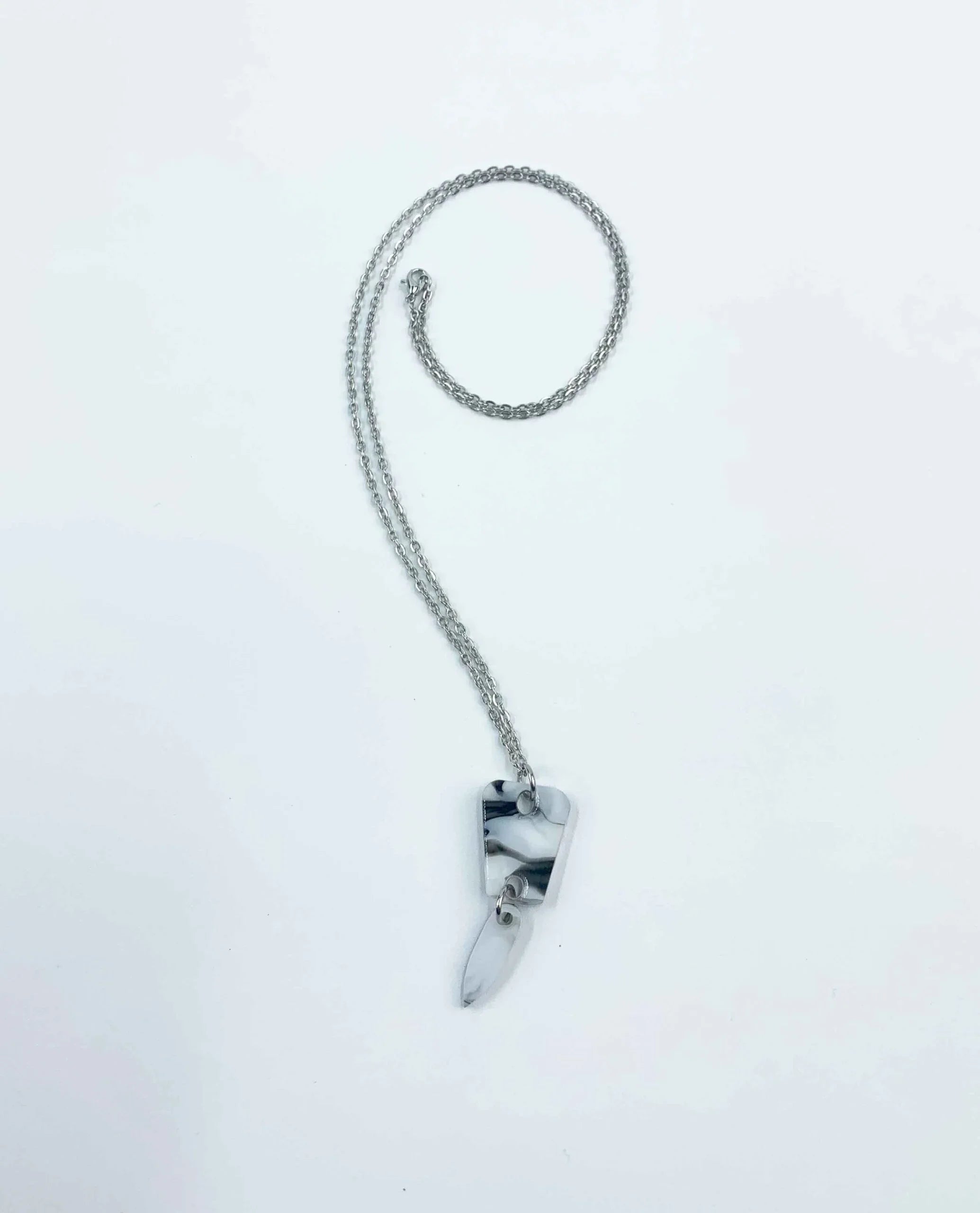Collar Minimalista de Cadena Plateada con Colgante Abstracto: presenta dos formas marmoleadas en gris y blanco sobre fondo blanco. Ideal para quienes buscan collares artesanales y joyas únicas para cualquier look.