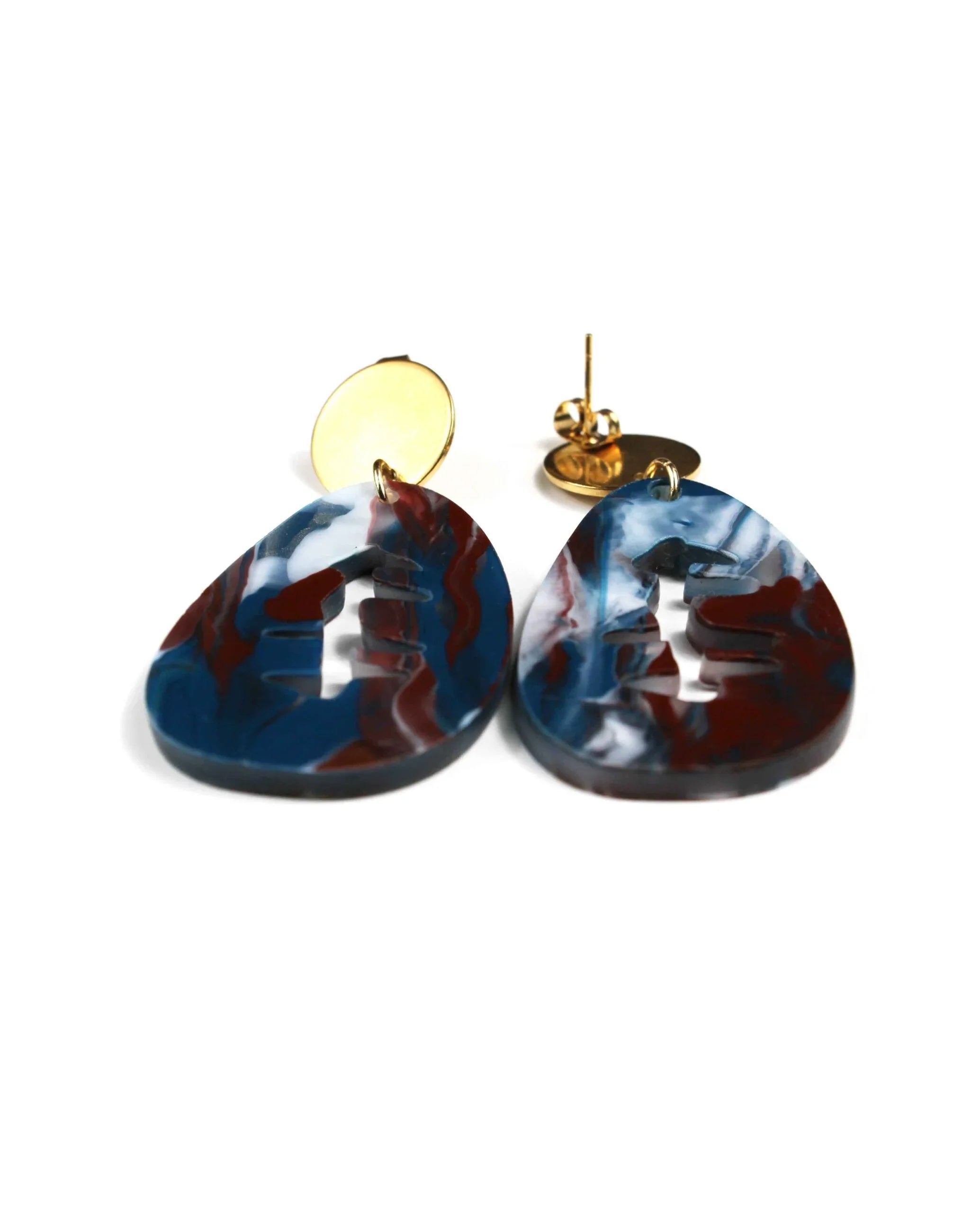 Pendientes mármol marrón, azul, blanco y dorado: elegantes aretes con base dorada circular y colgantes planos en forma de lágrima con diseño marmoleado y recortes centrales. Añade un toque de magia y color a tu estilo.